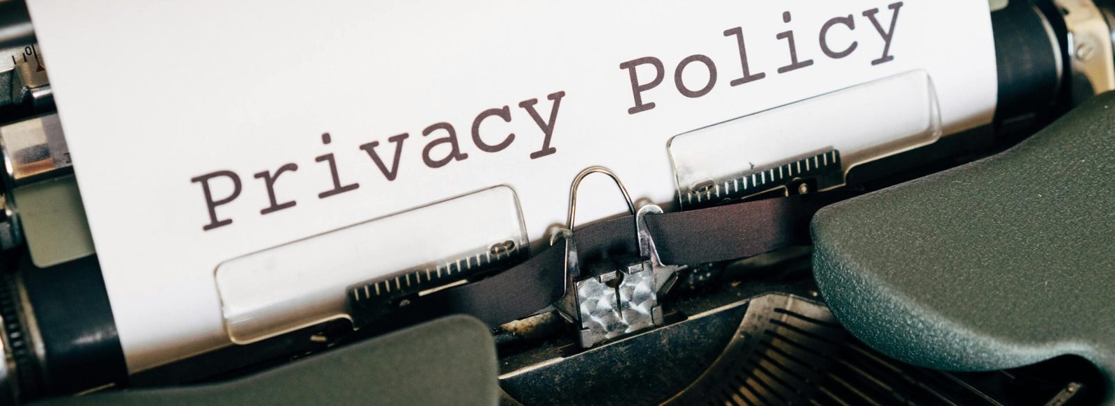 A vintage typewriter writing 'Privacy Policy' on paper, capturing an old-school conceptual theme.